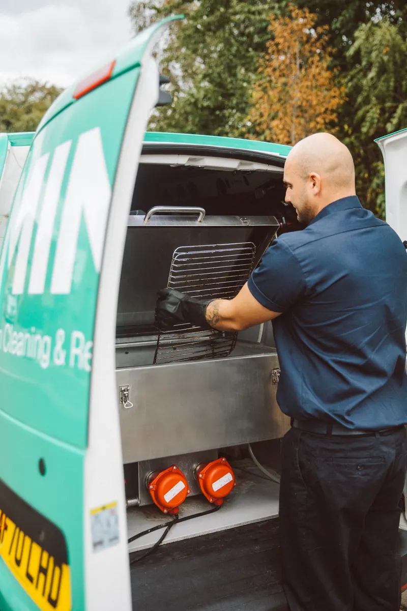 Taylor cleaning oven racks in the heated dip tank inside the MINT van