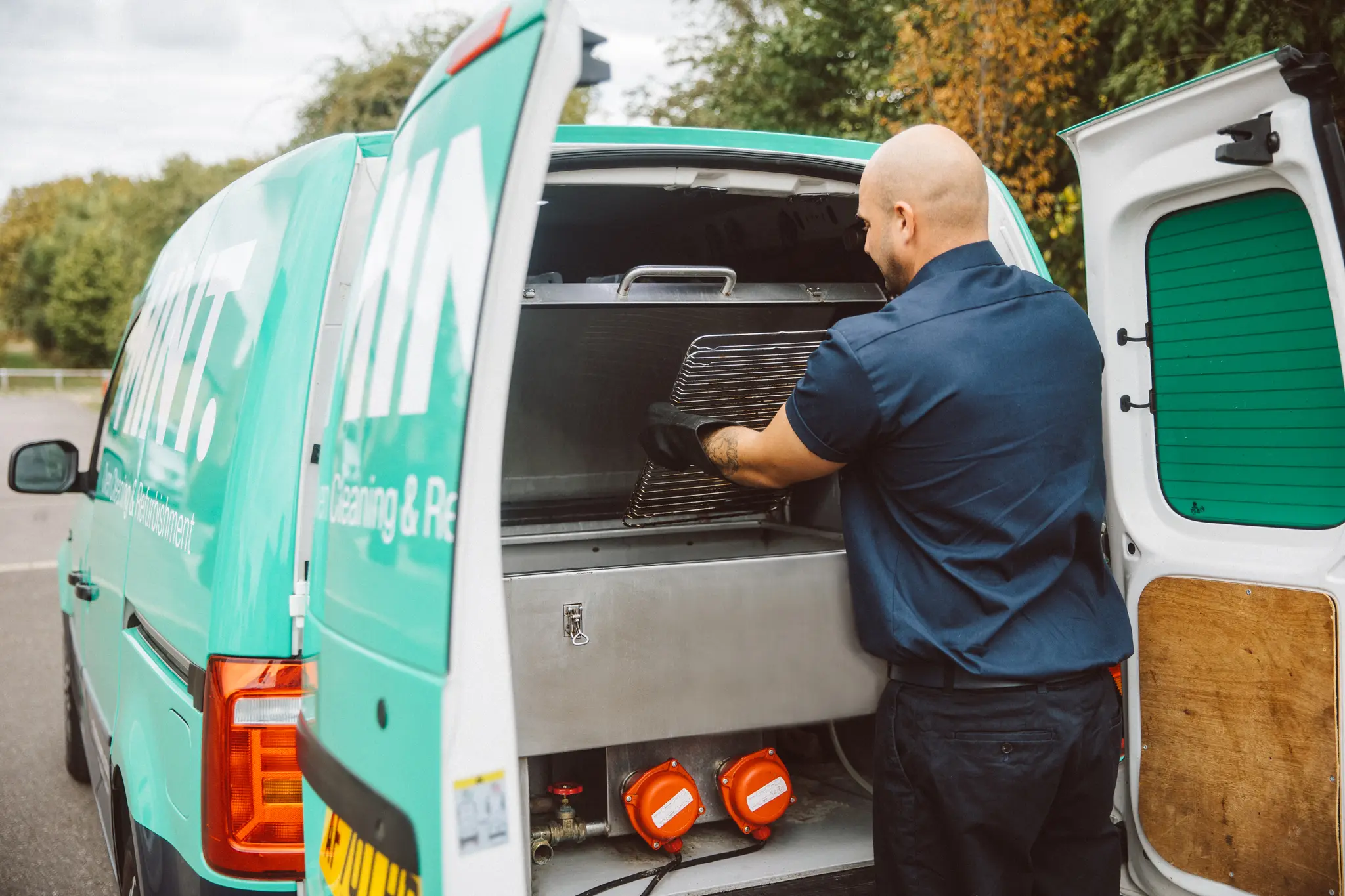 Taylor loading an oven rack into the dip tank in the MINT van