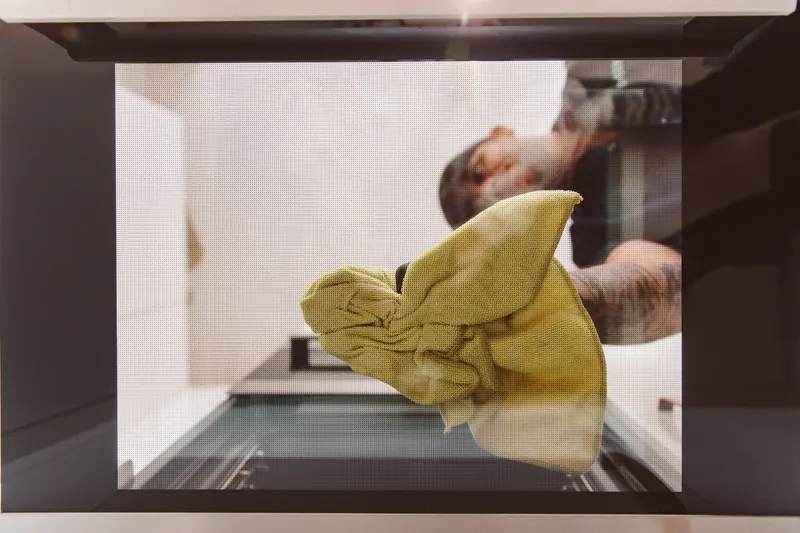 Taylor cleaning the oven glass with a cloth