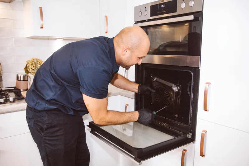 Taylor cleaning the inside of an open oven
