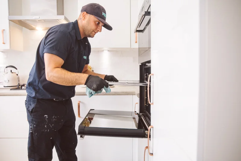 Taylor handling a removed oven door panel during reassembly